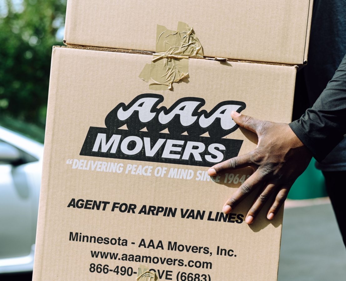 Person picking up boxes with AAA Movers info on them