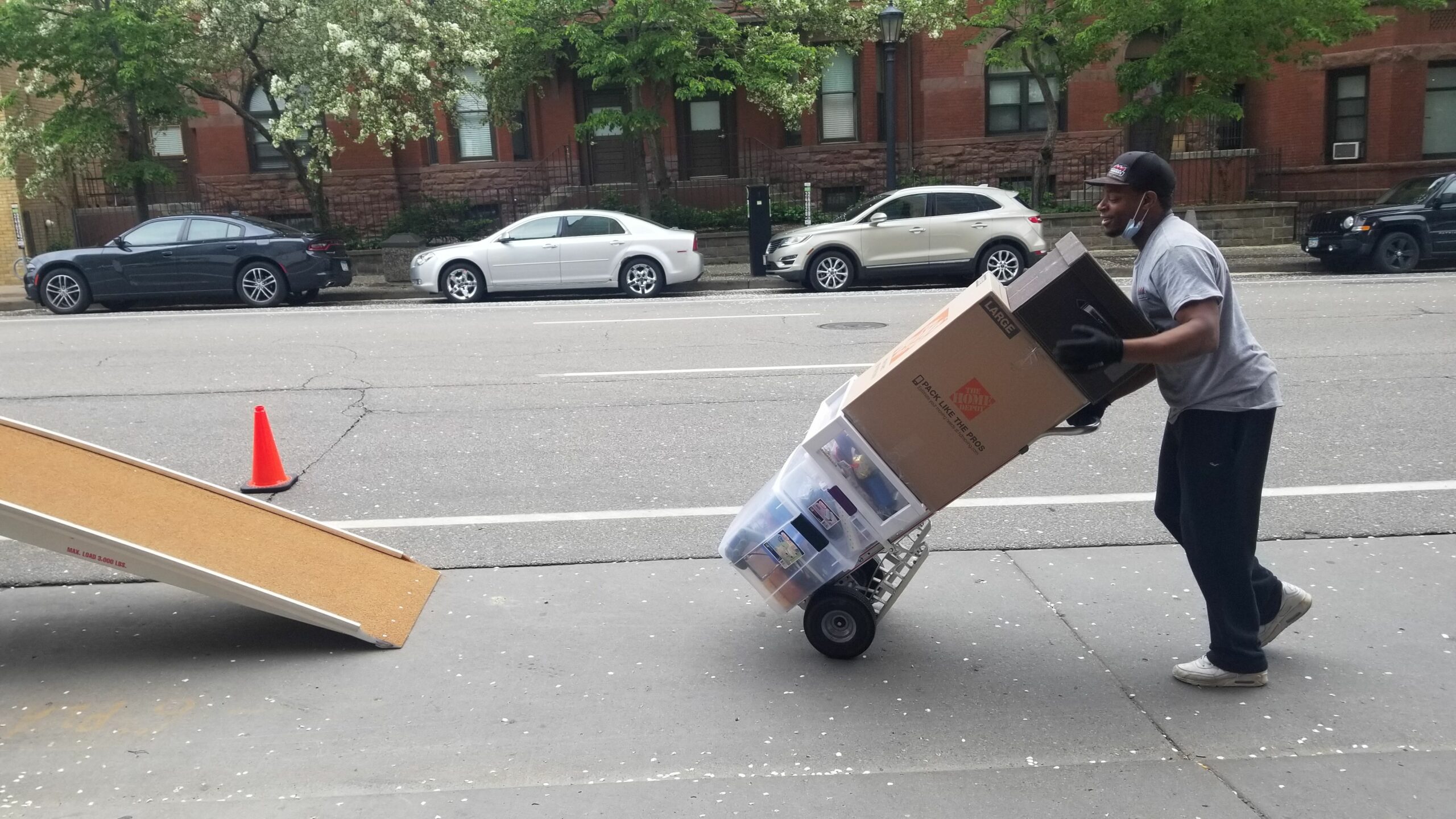 Mover rolling a stack of boxes toward a ramp