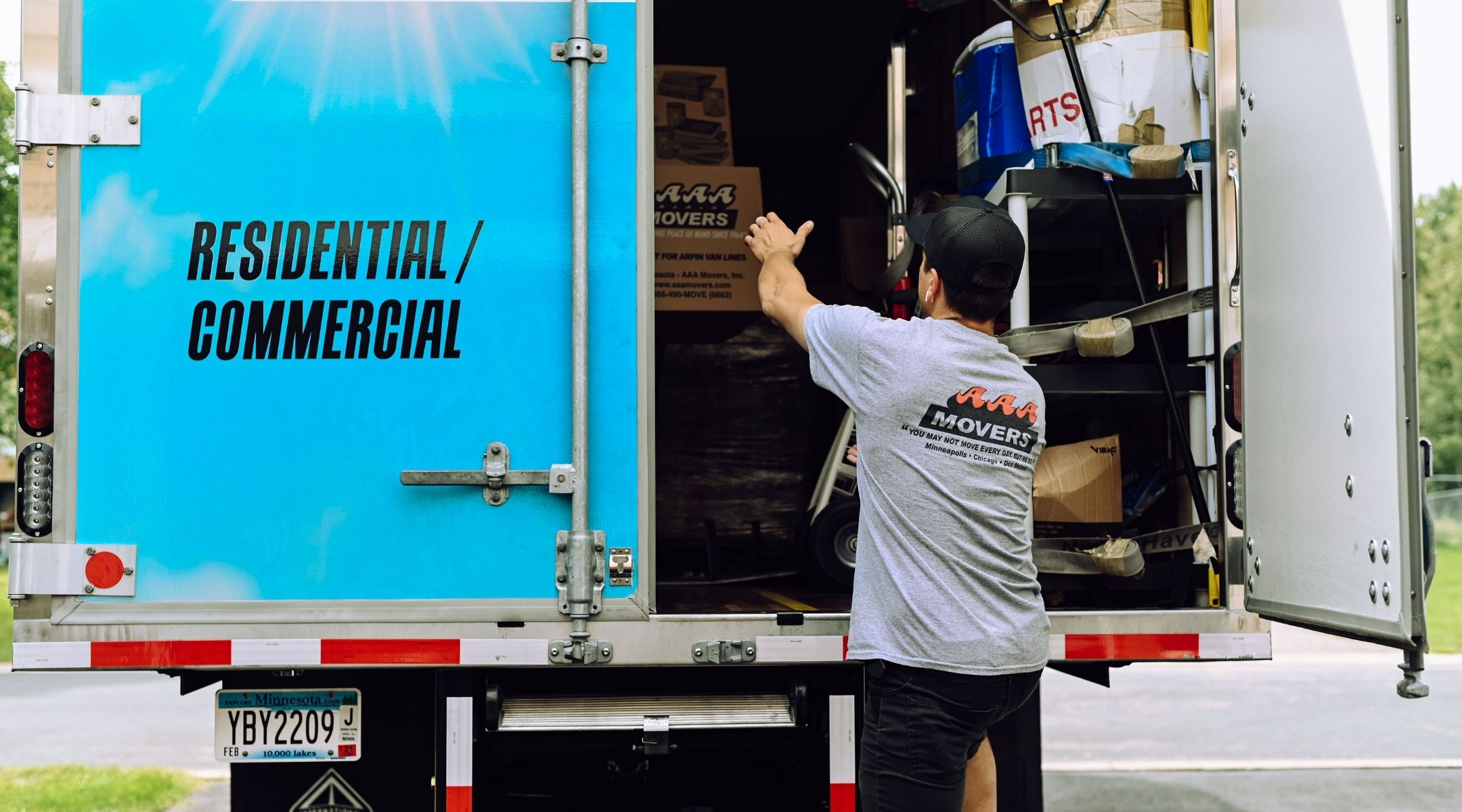 mover closing the back door of moving truck